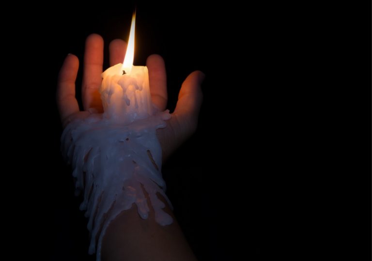 person trying wax play melting candle on thier hand